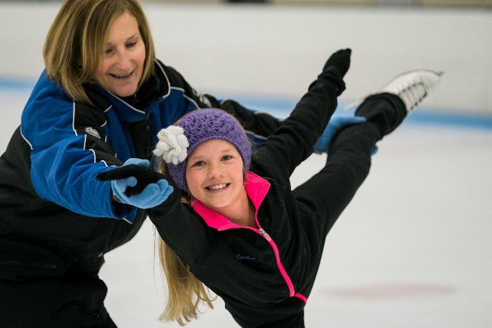 Female coach helping a young female athlete with a spiral 