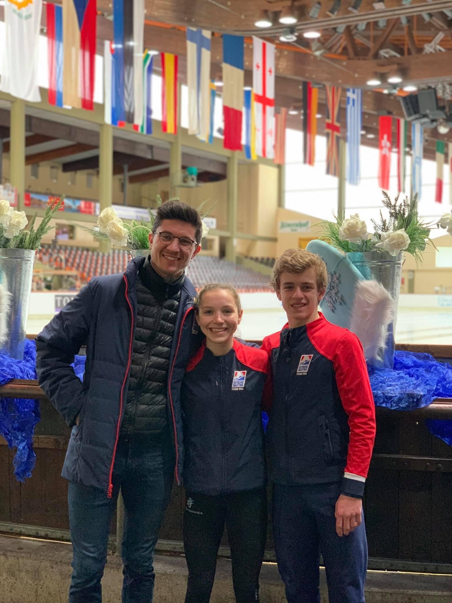 Colin McManus in glasses with two young skaters in Team USA jackets.