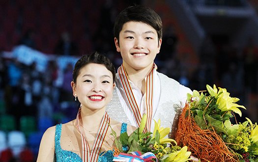 Maia Shibutanoi and Alex Shibutani smile for the camera with their medals and flowers at the world championships.