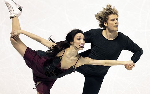 Meryl Davis skates with leg outstretched and Charlie White by her side at the 2013 World Championships.