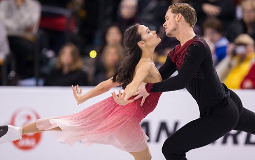 Madison Chock and Evan Bates stare into each other's eyes while performing a step sequence. 