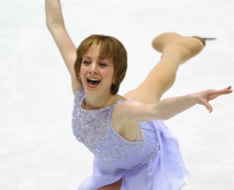 Sarah Hughes with short, light hair skating backward in a light purple dress.