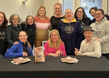 Marina Shelton, dressed in pink, is surrounded by fellow skaters and coaches following a talk and book signing.