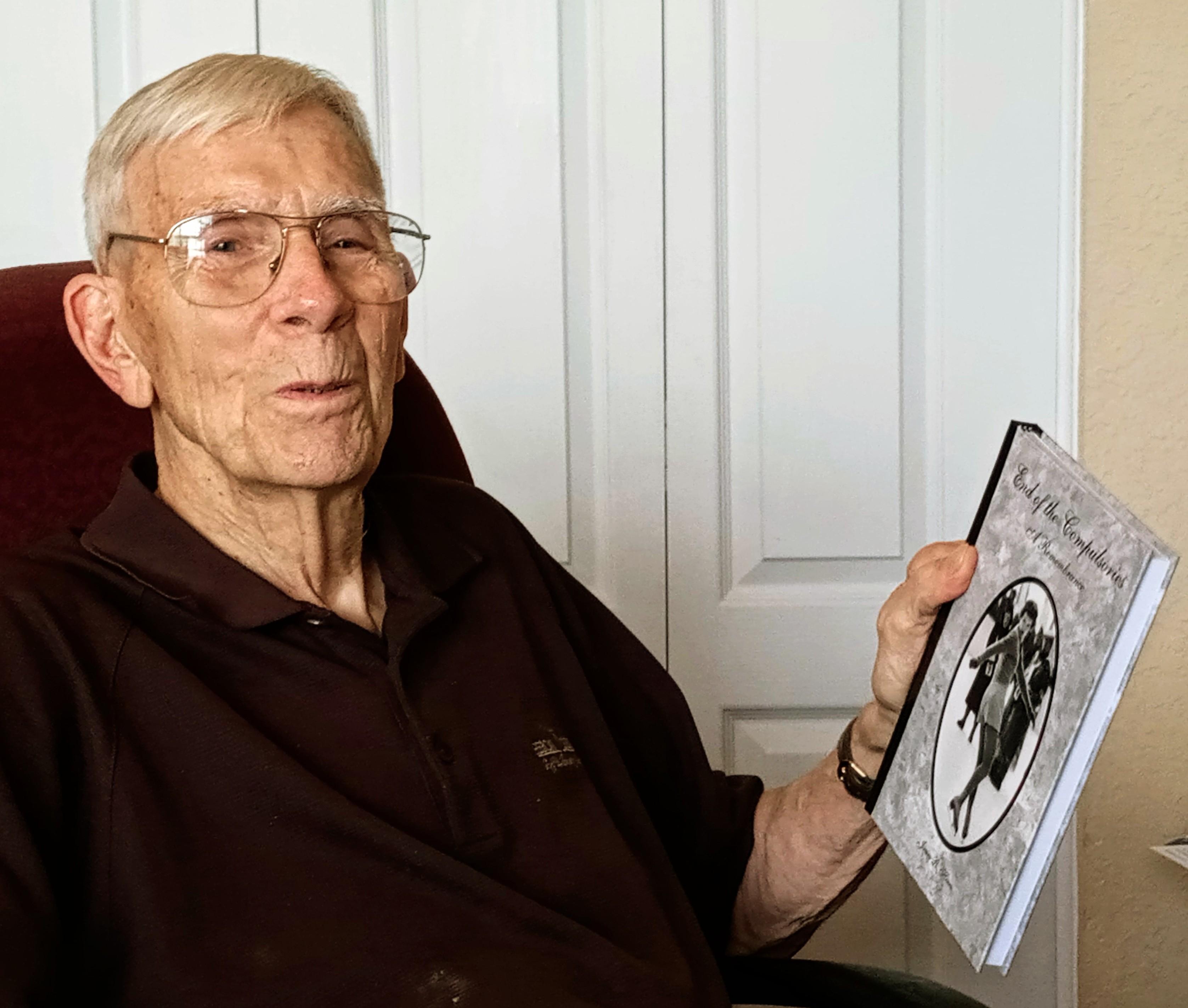 Dr. Hines holds up his book, "End of Compulsories."