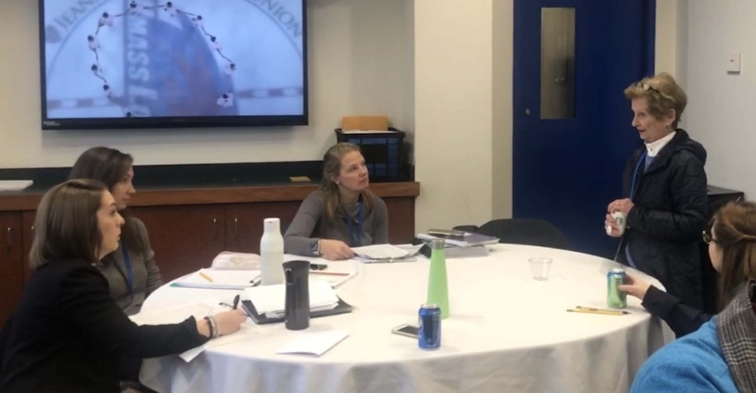 Ann Fauver sits with a group of young officials at a table.