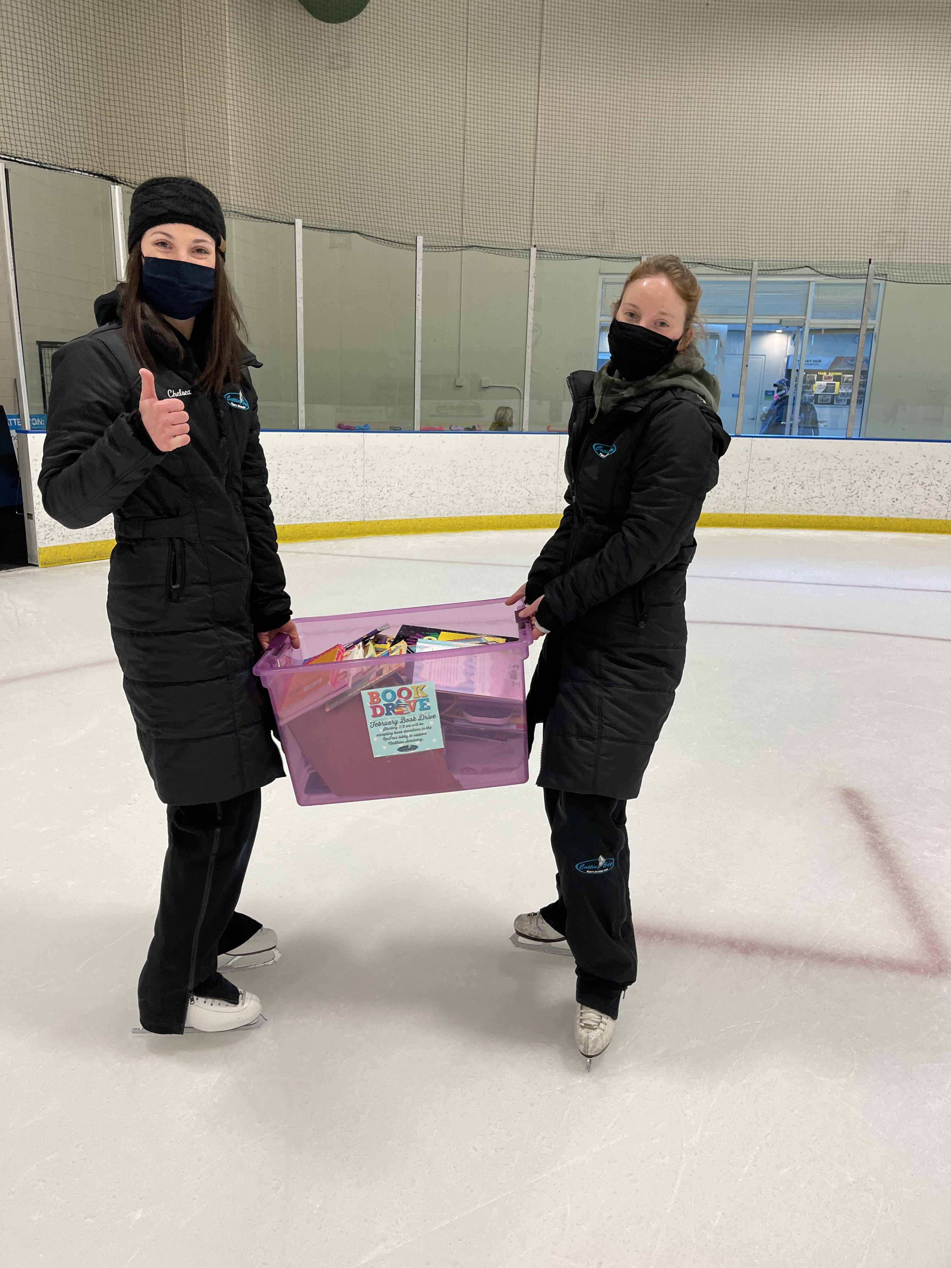 CEFSC Book drive Club Coaches Chelsea Strouf and Lindsay Goessl helping to collect books donated while skating on the ice.