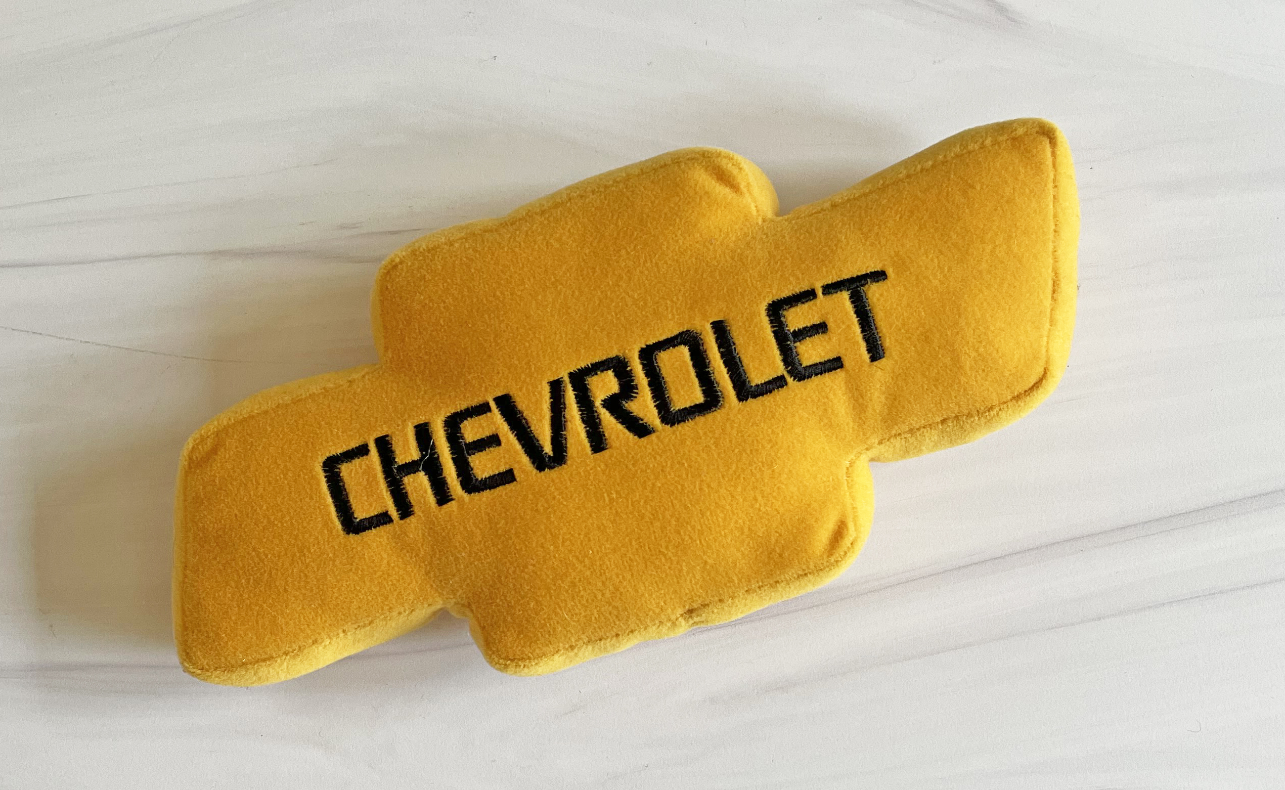 A yellow plush bowtie with the word "Chevy" written across it.