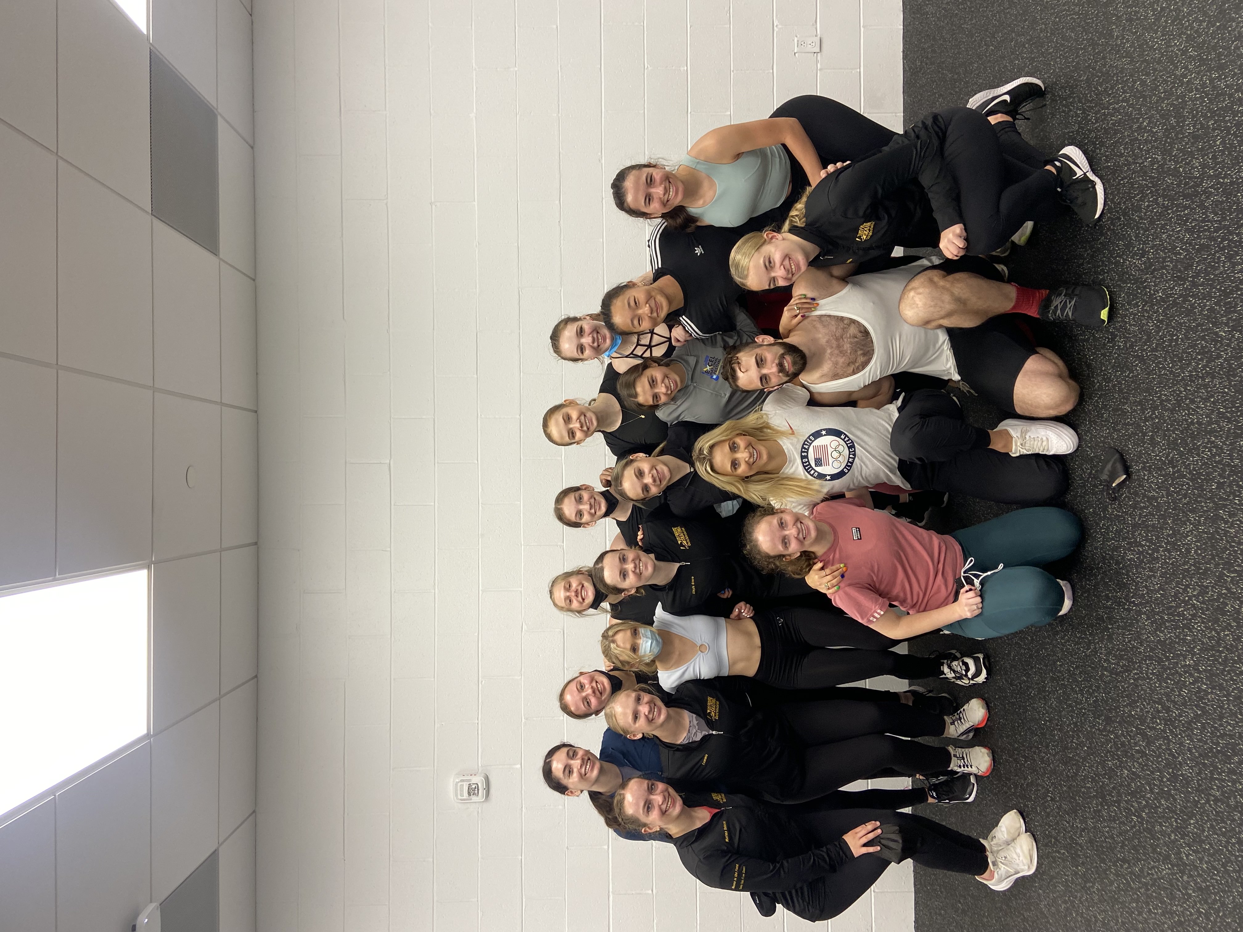 A group of skaters in workout gear pose with Olympian Ashley Cain.