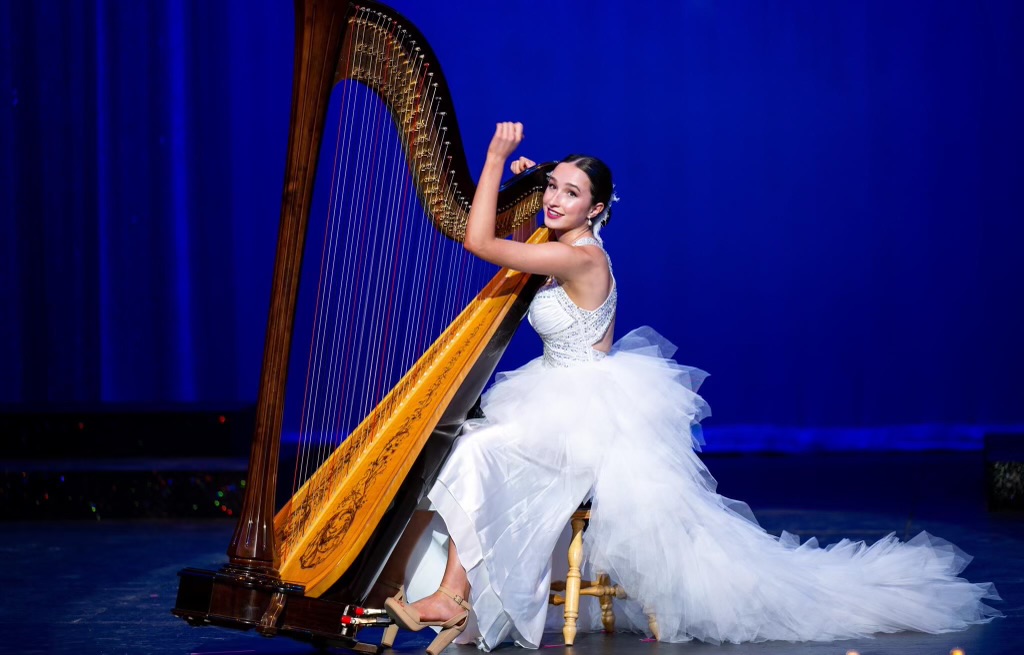 Dressed in white, Joelle Simpson plays the harp during the Miss South Dakota Pageant.