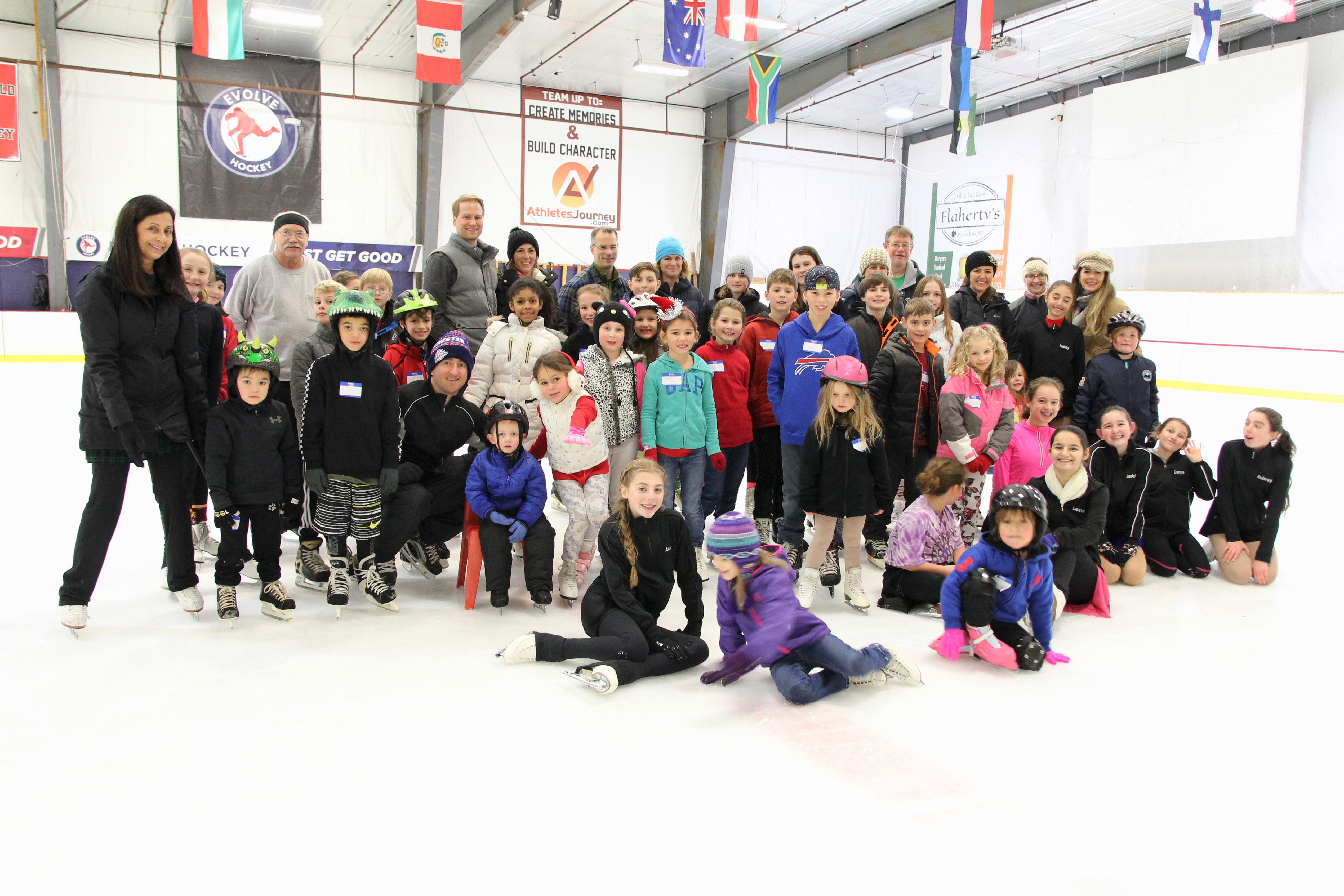 Skaters partcipating in Open House pose for a group photo with coaches and volunteers.