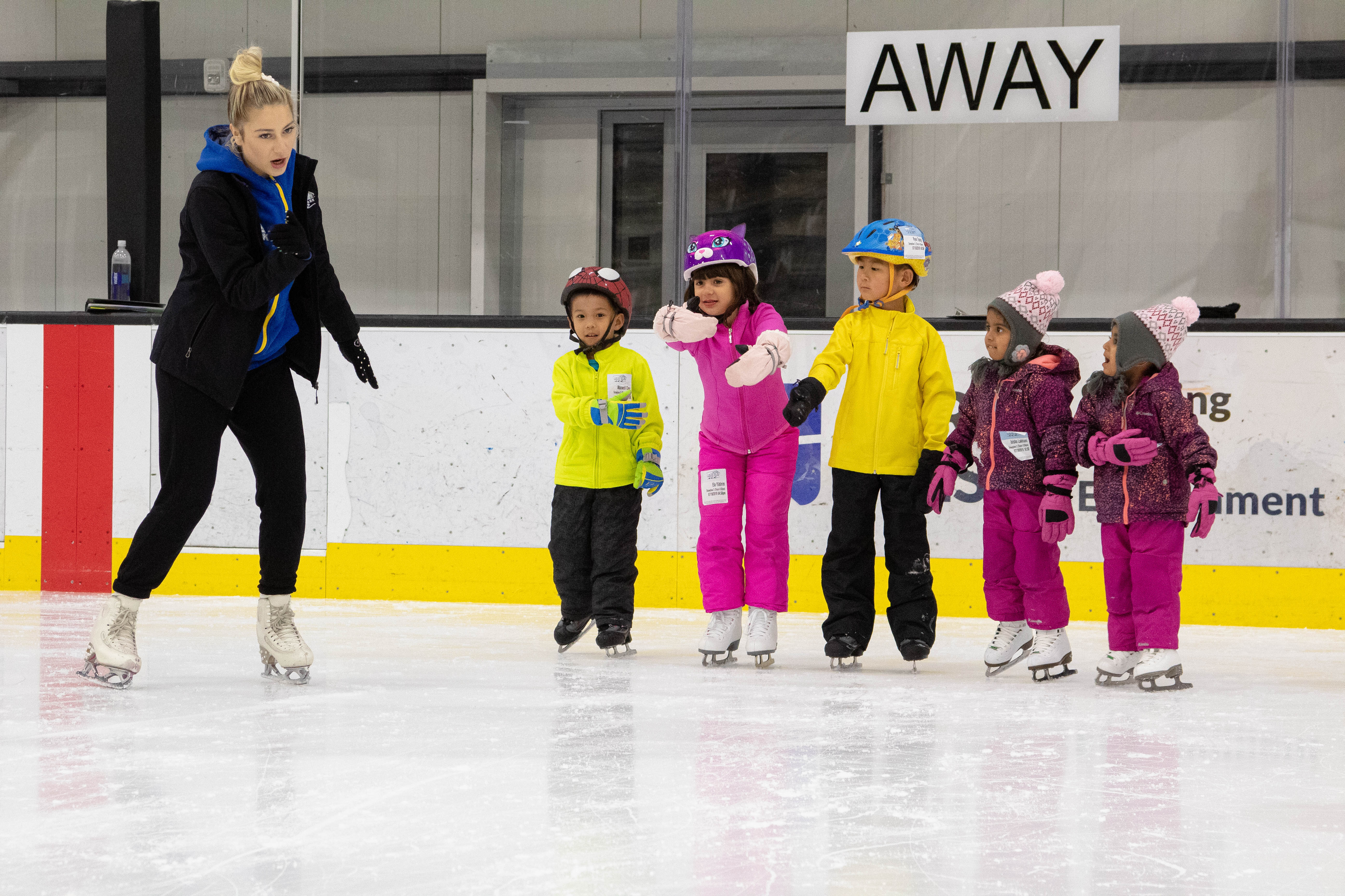 Children dressed in their heavy coats, some with helmets, glide together in a Learn to Skate USA class in Irvine, Californial.