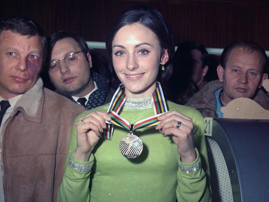 Peggy Fleming shows off her 1968 Olympic medal wearing her iconic green dress.