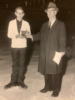 Dr. Hugh C. Graham, Sr., president of the Tulsa Figure Skating Club, presents an award to Greg Robbins, the winner of the preliminary boys event at the annual club competition.