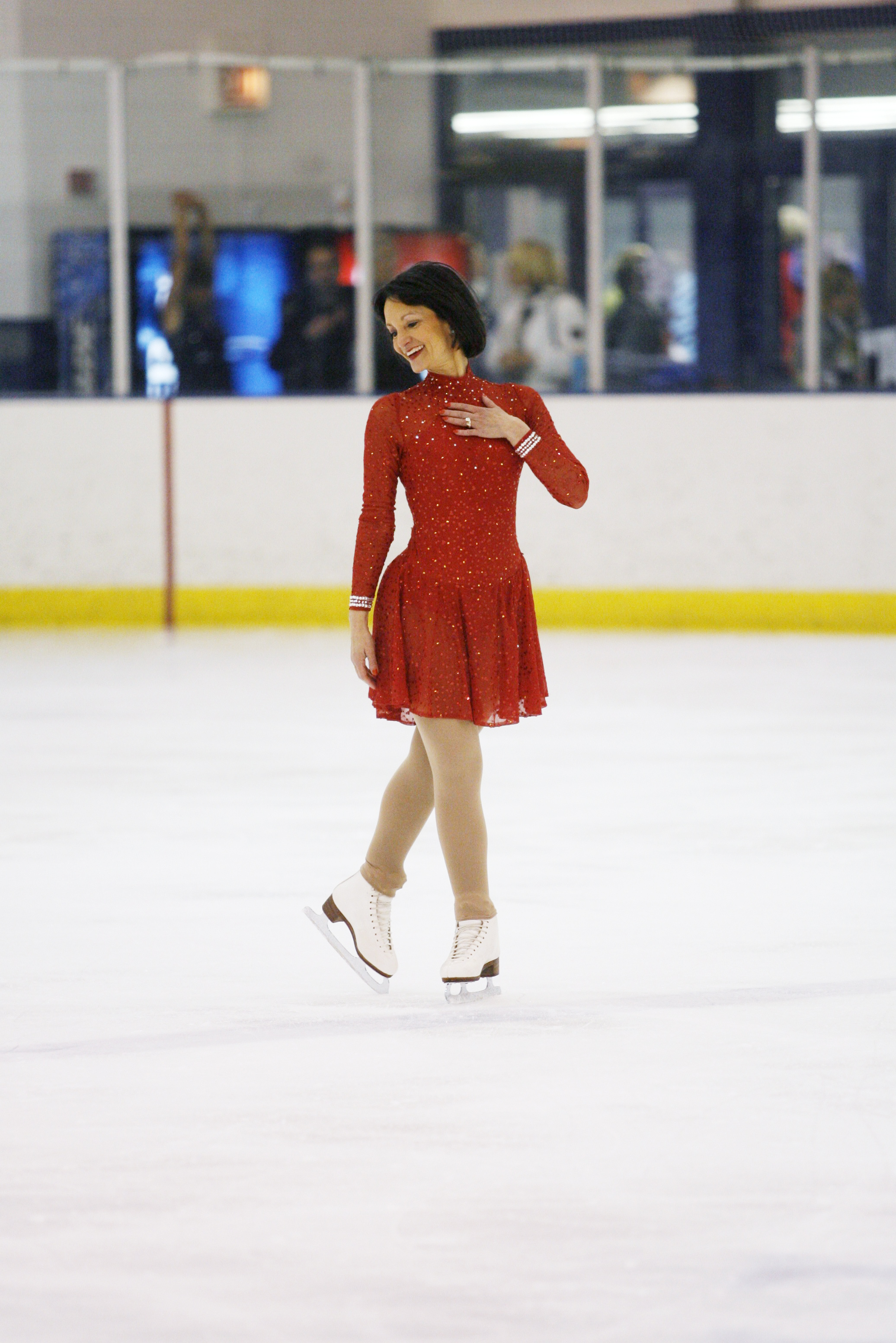 Rhea Schwartz skates across the ice in a flowy red dress.