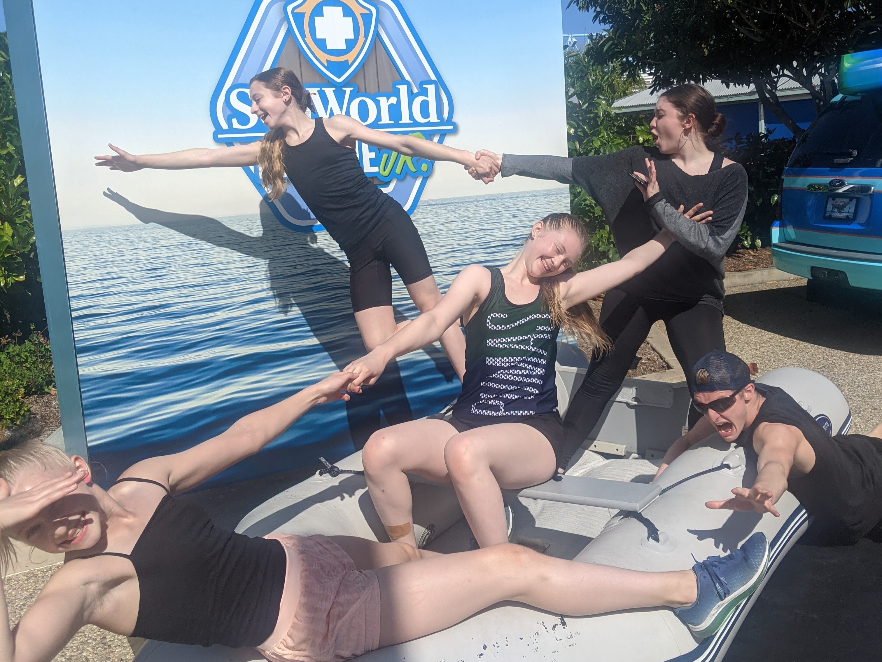 The Rudedenman children, in their swimwear, create a human link in front of a Sea World sign.