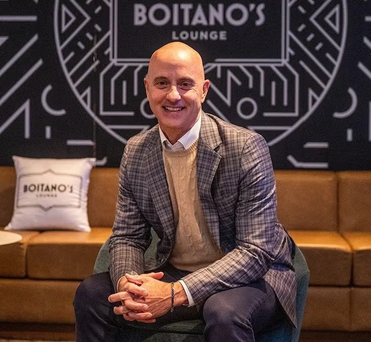 Brian Boitano smiles as he sits in Boitano's Lounge