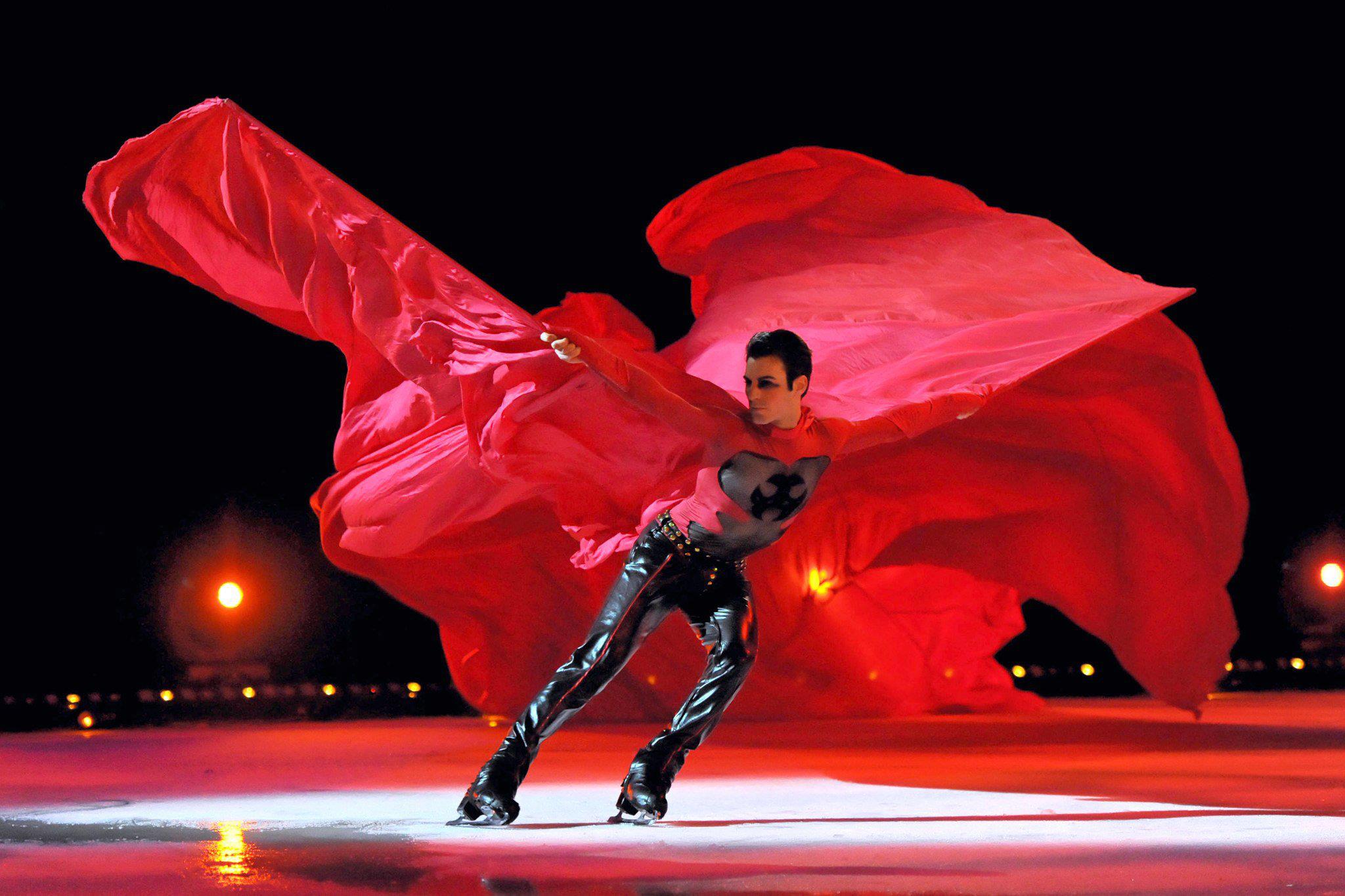 MIchael Solonoski skates under the spotlight with a bright red cape.