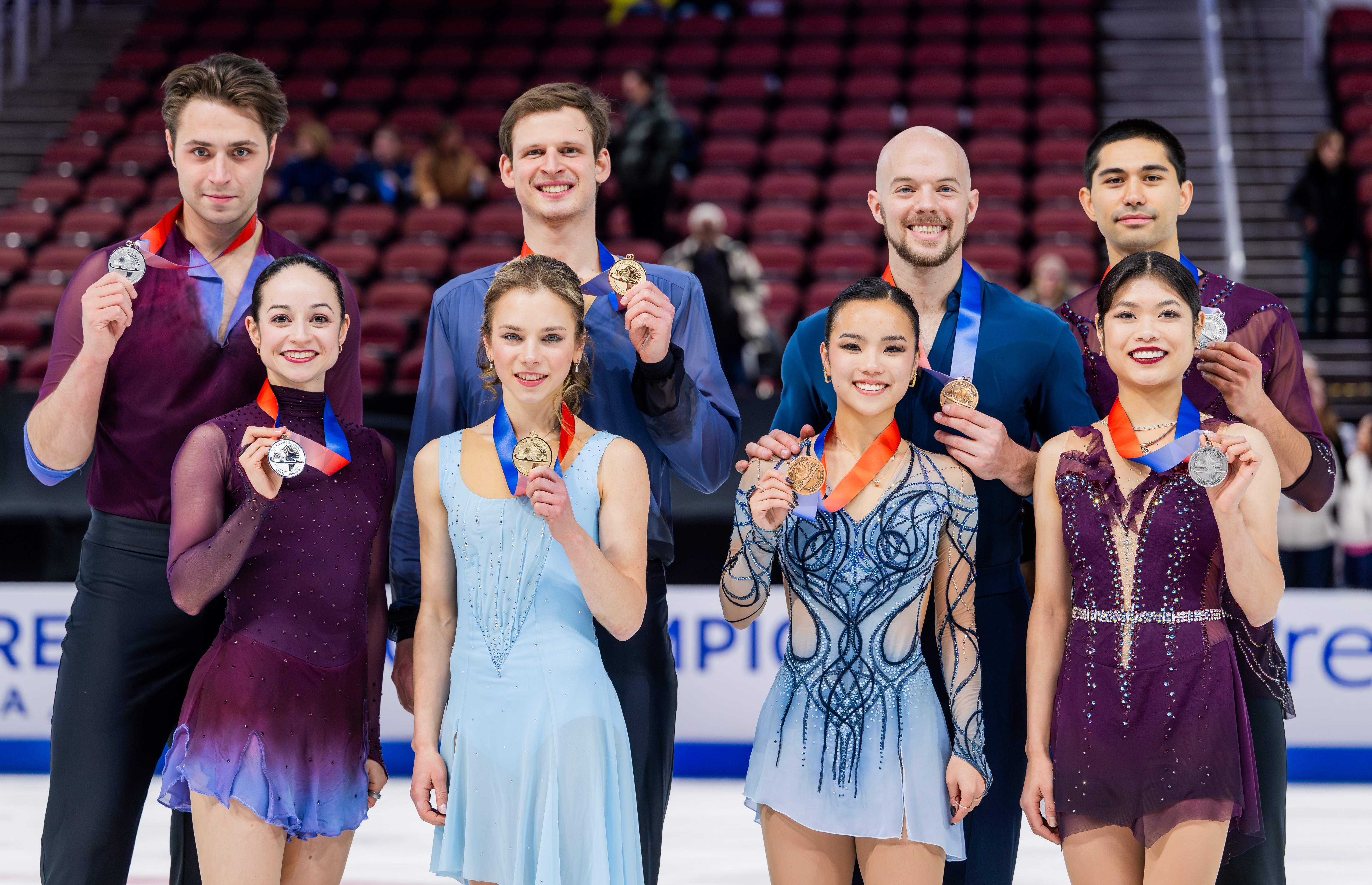  The 2025 championship pairs podium stands together on the ice and holds up their medals during the victory ceremony. (L-R): Katie McBeath and Daniil Parkman, Alisa Efimova and Misha Mitrofanov, Ellie Kam and Danny O'Shea, and Emily Chan and Spencer Howe