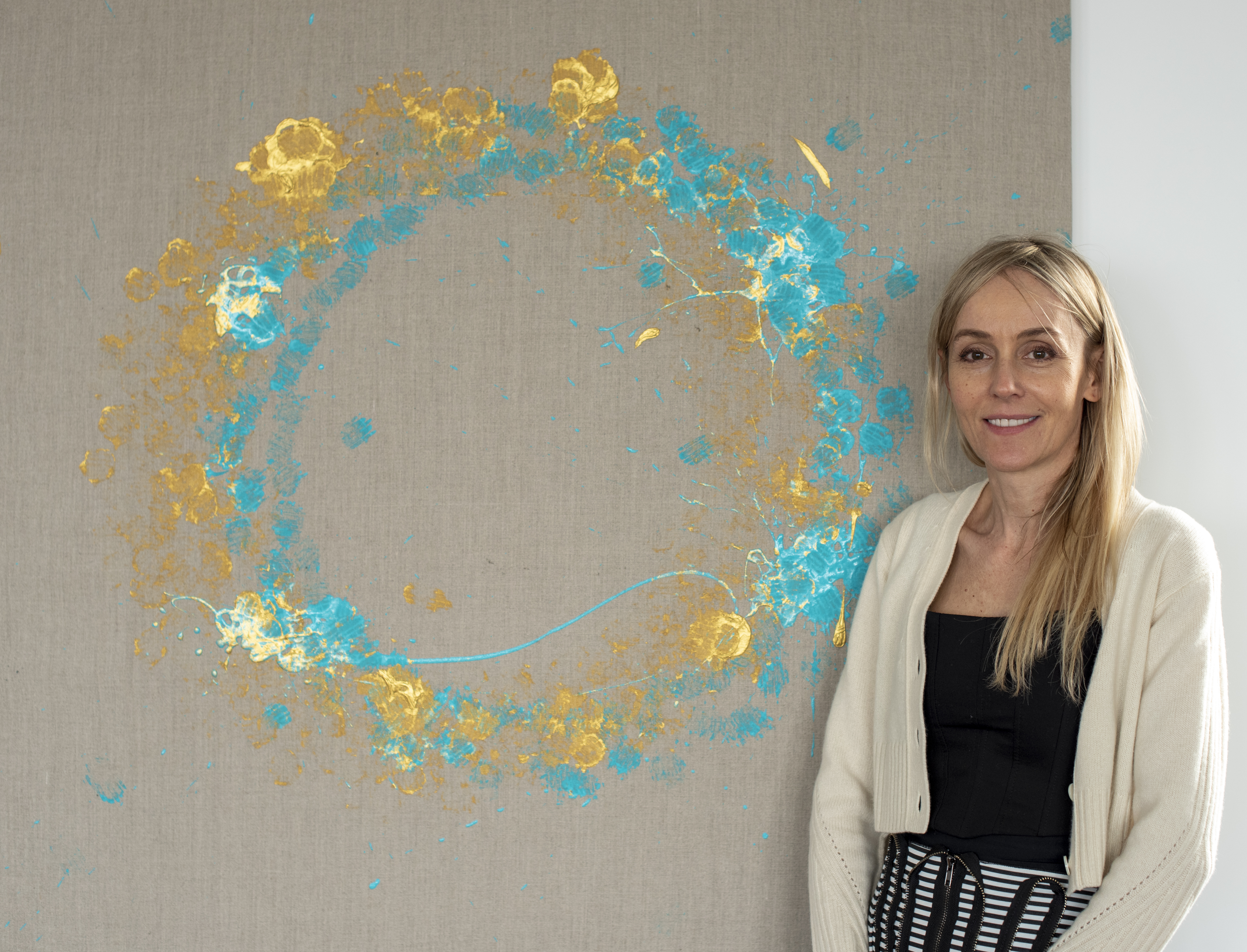 Agnieszka Pilat displays her painting titled Sunrise March which is a blue and yellow wreath.