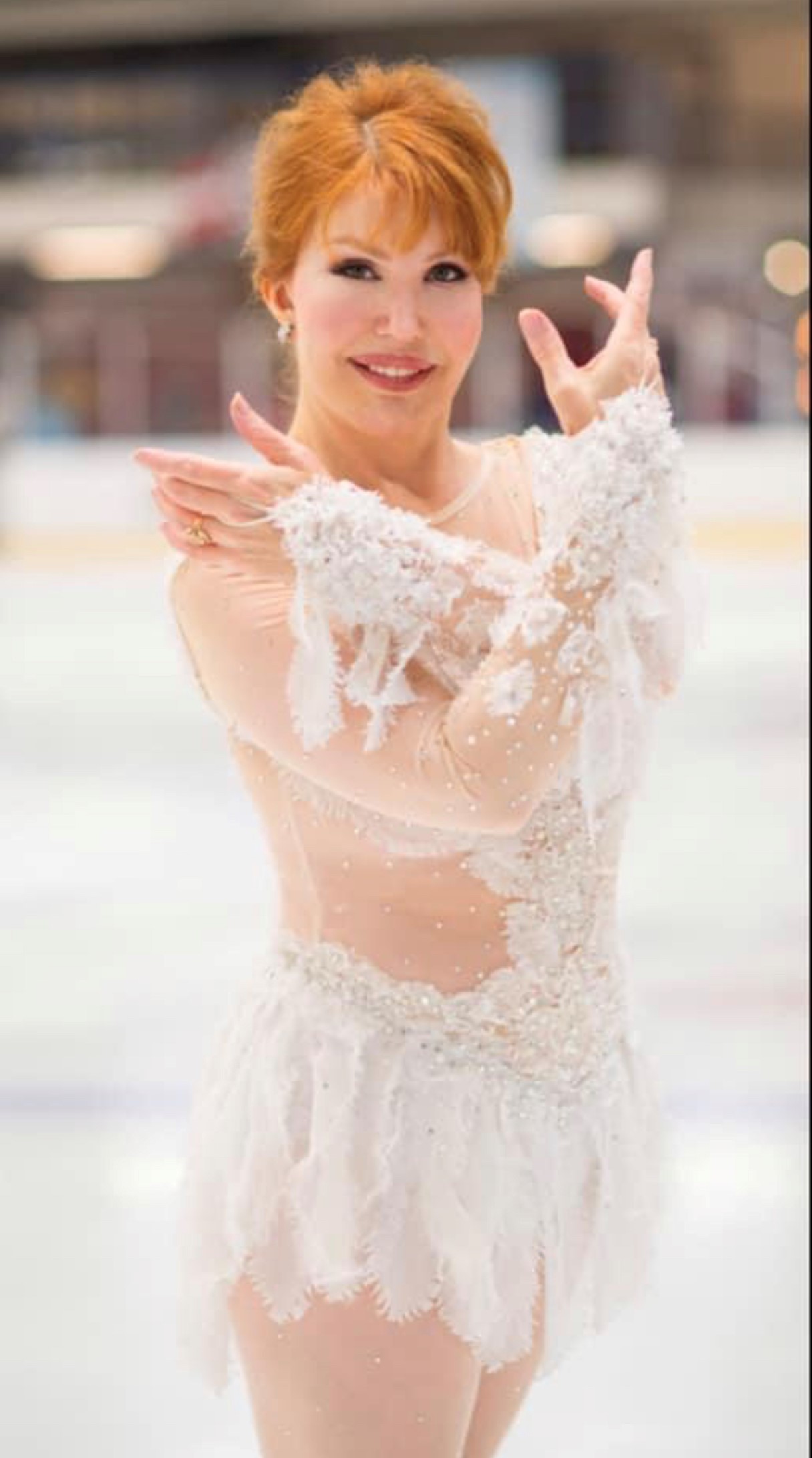 Billie O'Neel poses in a white dress with her hands out front. 