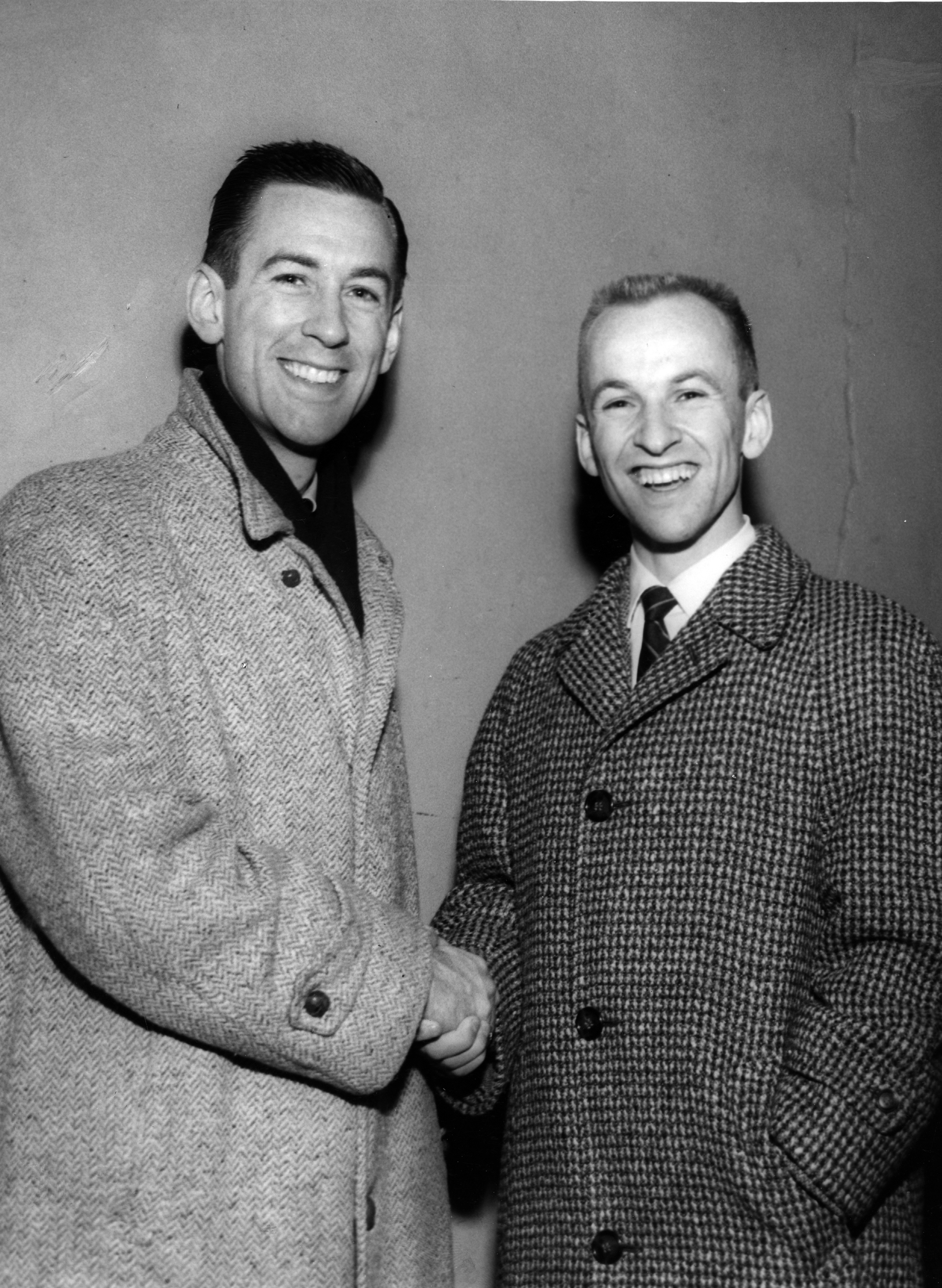 David and Hayes Jenkins shake hands while smiling at the camera.