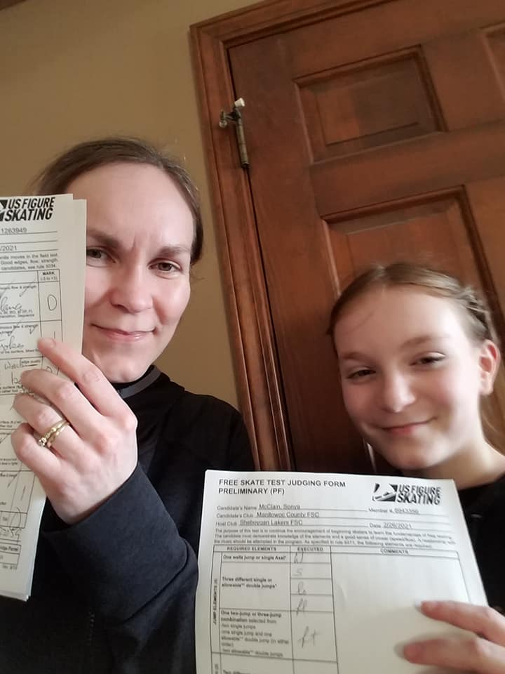 Maria and Sonya McClain hold up their tests passed papers.