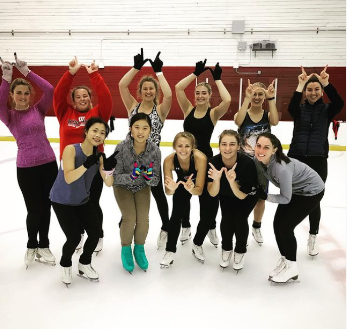 A group of collegiate skaters fool around on the ice.