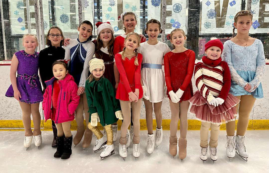 Great River Figure Skating Club skaters pose for a photo wearing various Christmas and winter themed costumes. 