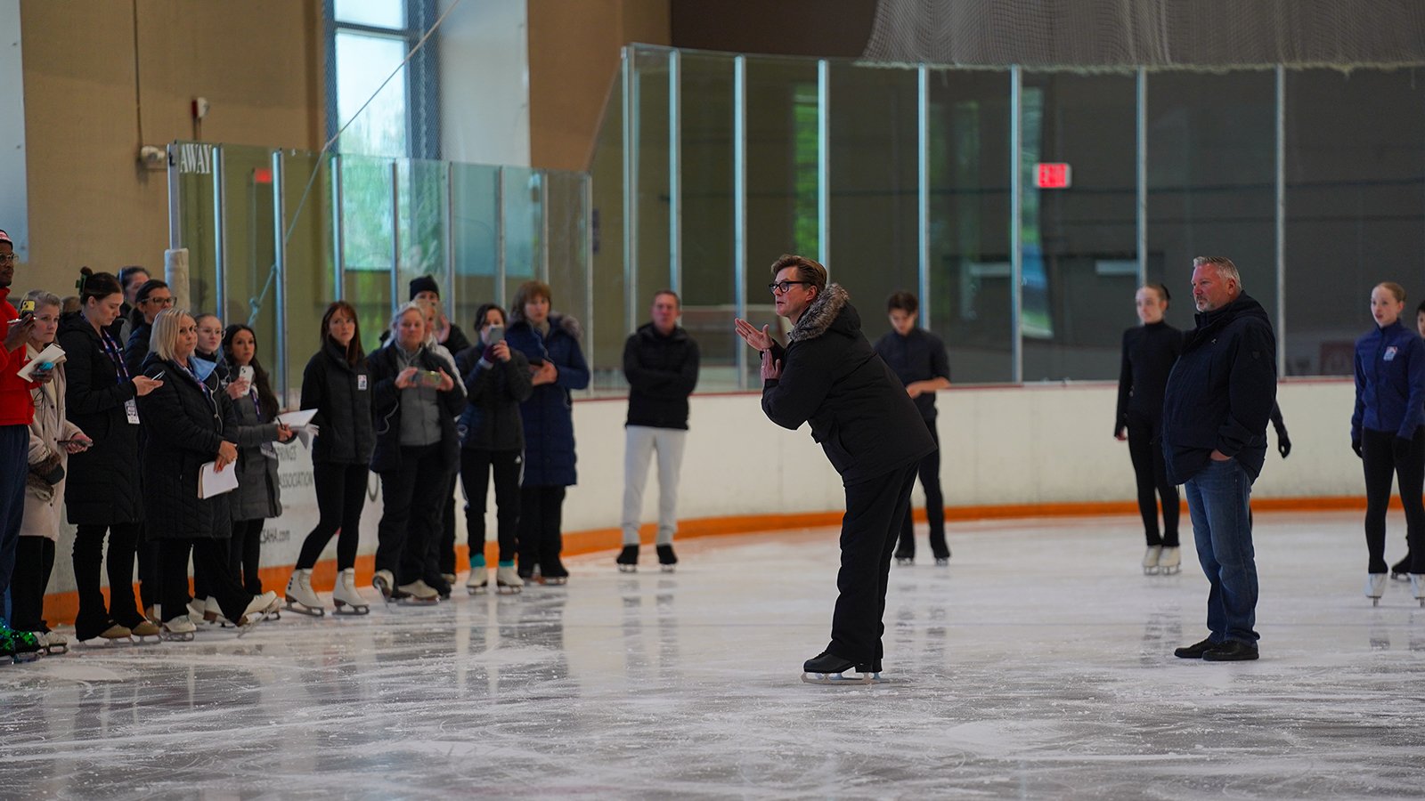 Coach Peter Johansson stands in front  and talks to a group of coaches on the ice at the 2024 Access to Excllence