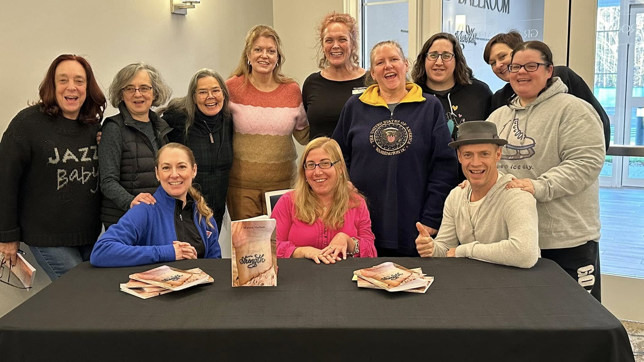 Marina Shelton, dressed in pink, is surrounded by fellow skaters and coaches following a talk and book signing.