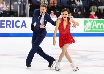 Madison Chock, wearing red, Evan Bates, wearing a black suit, perform to hit songs from the 50s, 60s, 70s.