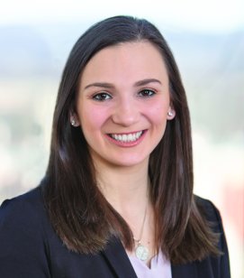 Headshot of Jordan Alexander. She is a woman with shoulder length brown hair wearing a white top and a black blazer